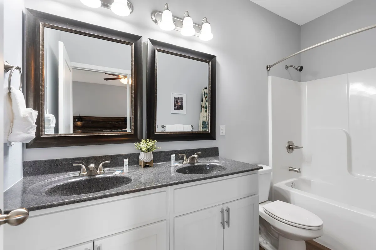 A spa-like bathroom with a double vanity, large mirrors, a soaking bathtub, and neatly arranged towels. The space is bright, fresh, and serene, creating a true retreat for self-care and relaxation.