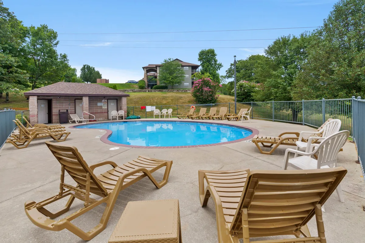 This image showcases a sparkling swimming pool surrounded by comfortable lounge chairs and lush green vegetation. The poolside shelter provides shaded seating, and the tranquil atmosphere invites guests to relax, swim, and socialize. The greenery hints at the vibrant summers enjoyed at the resort.